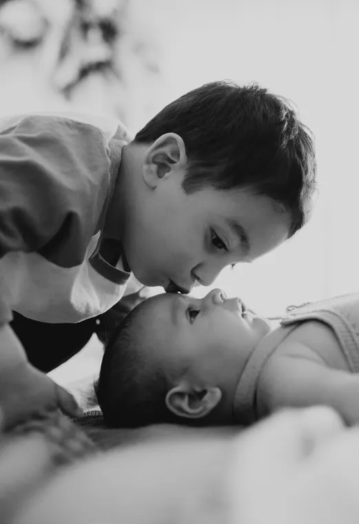 Foto hermano besando a bebé